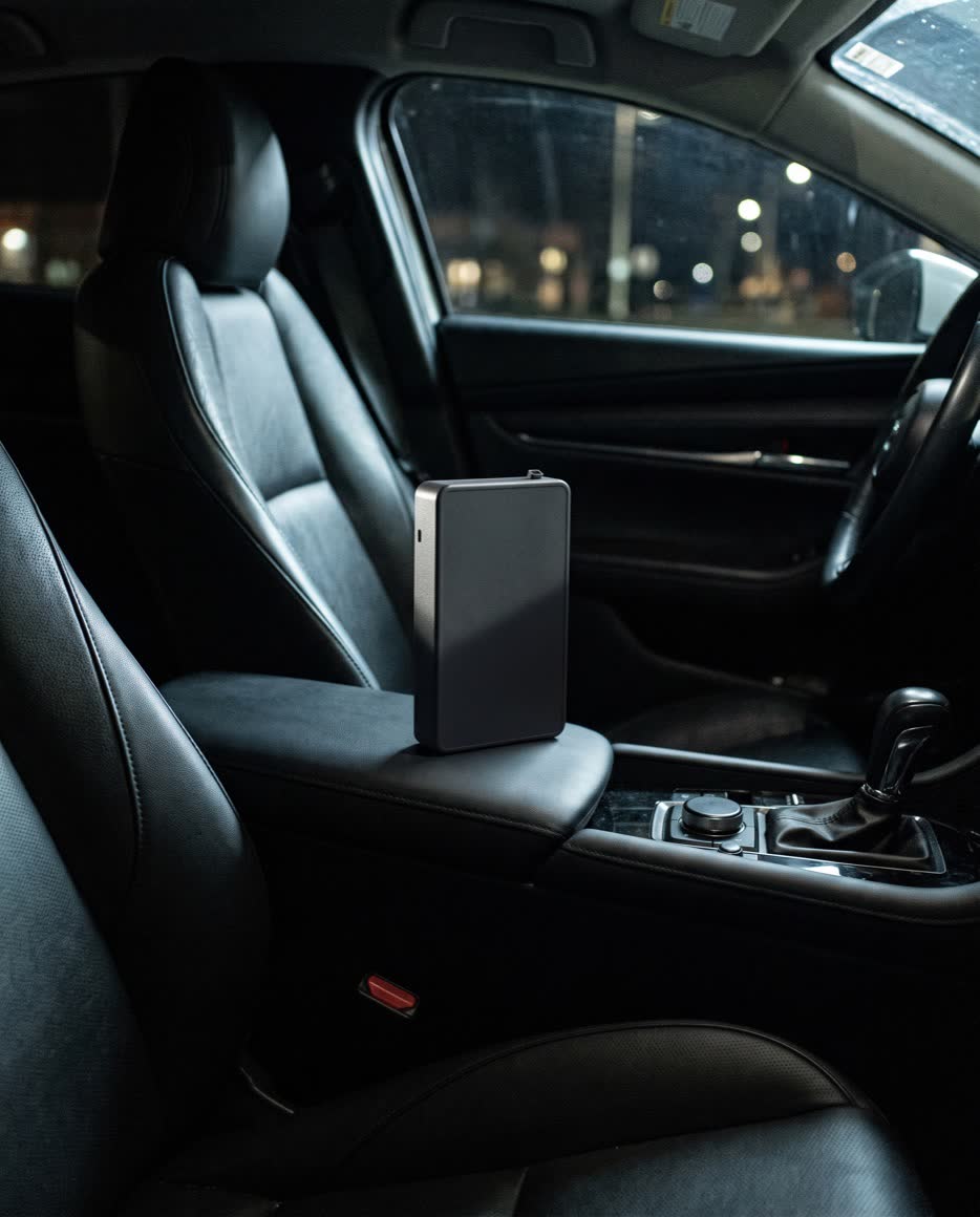 The diffuser standing upright on the passenger seat of a car at night