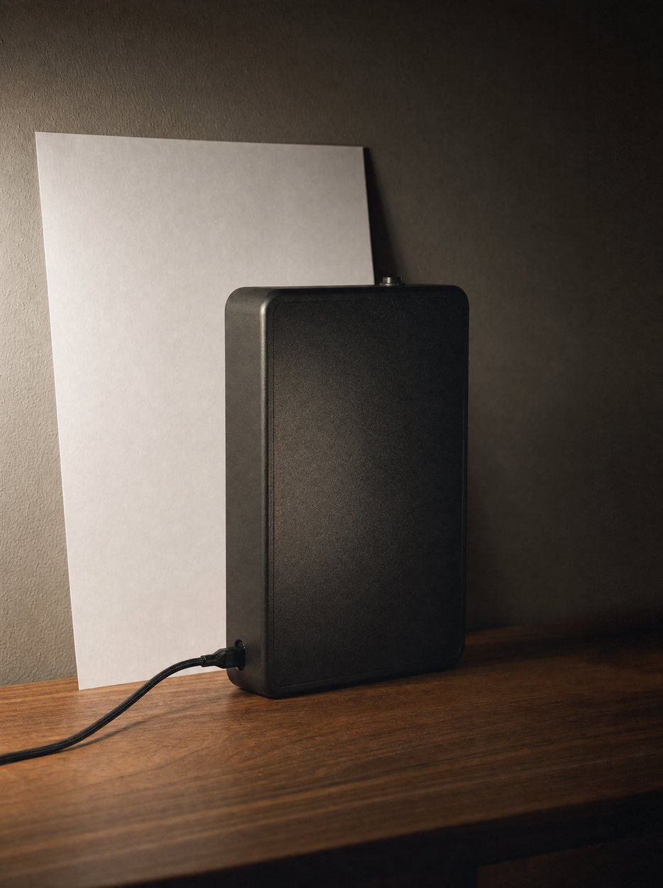 The diffuser charging by USB-C, cable running across the wood